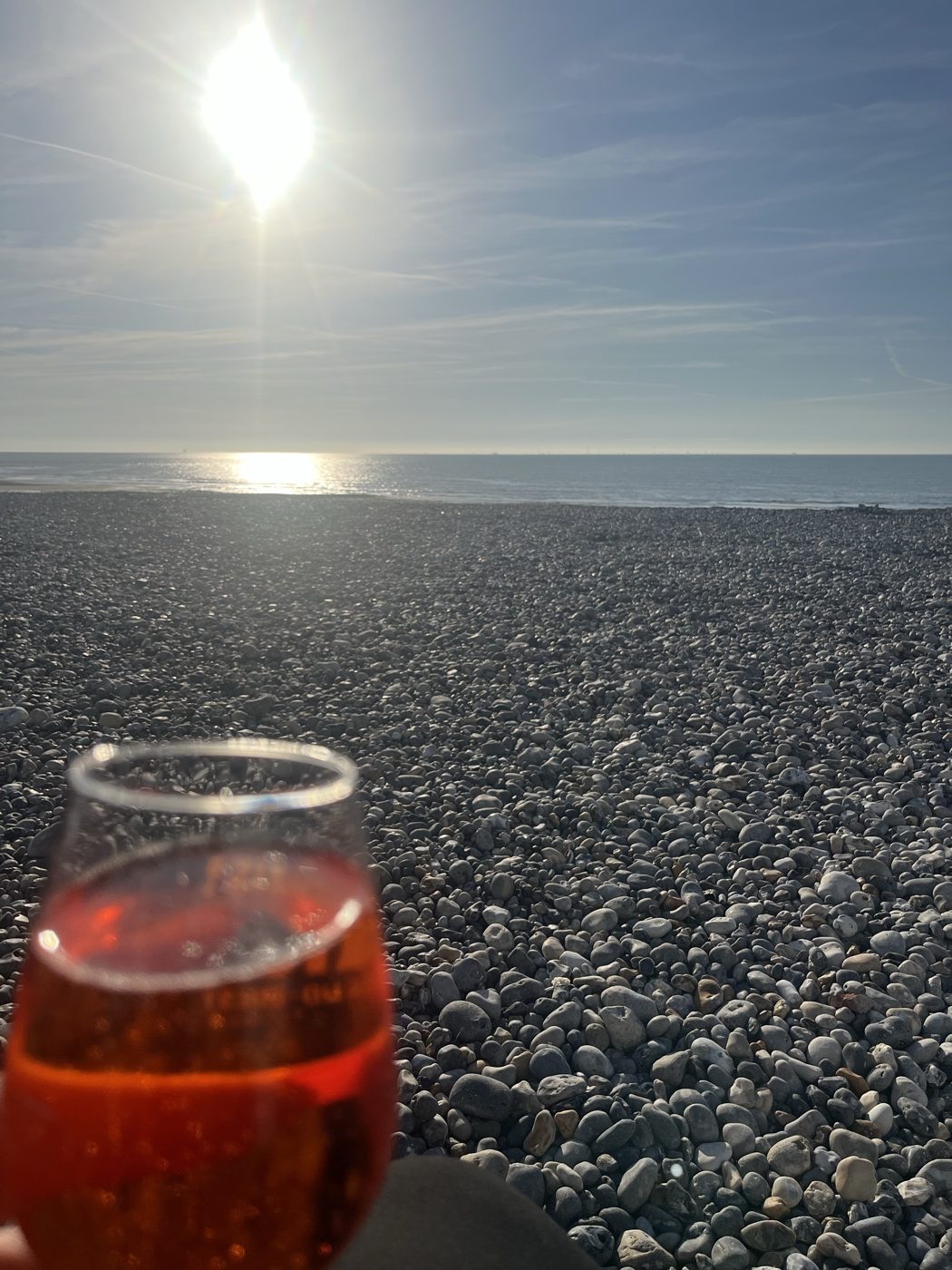 Verre d'apéritif face à la mer sur la plage de galets